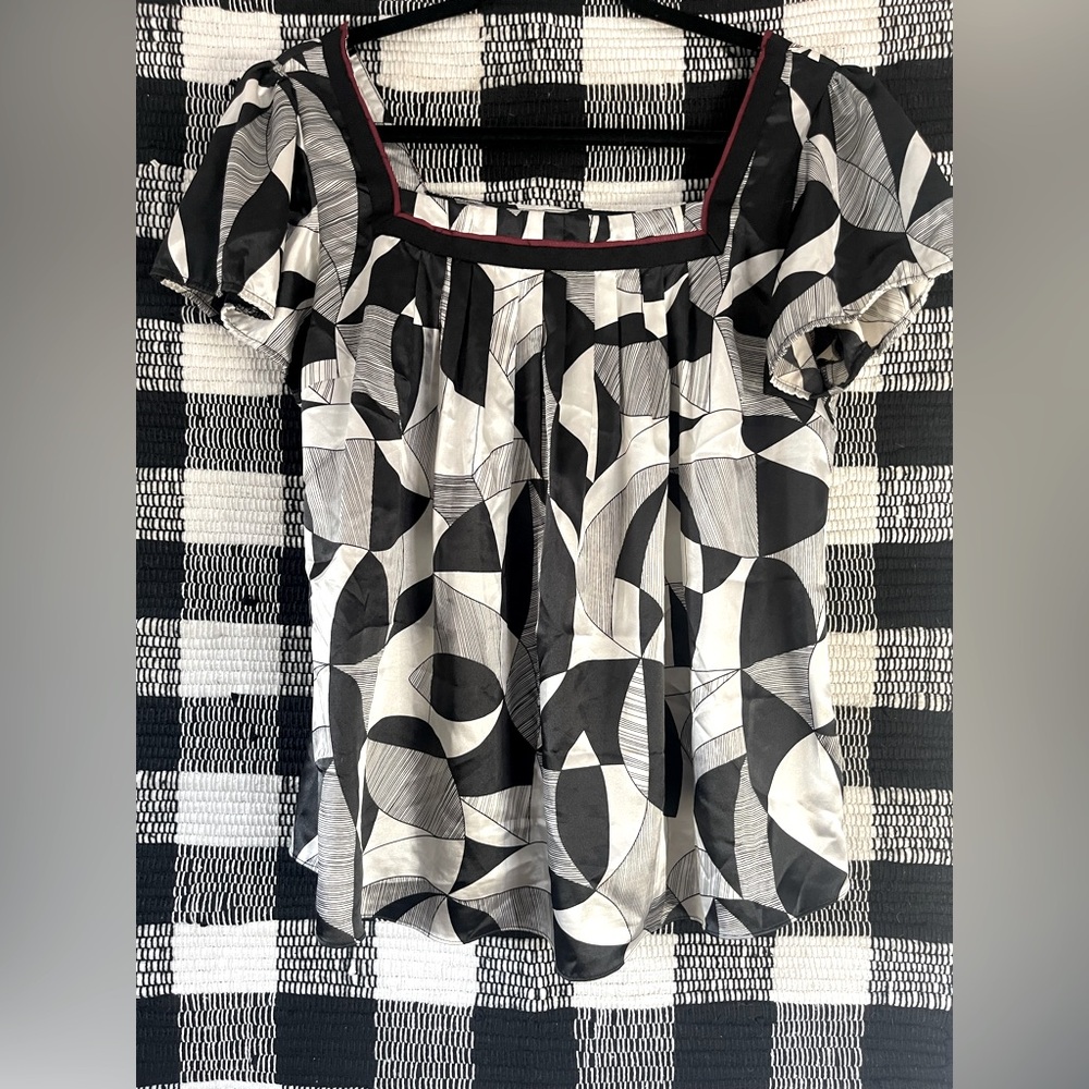 Black and white light weight tank with red trim around the edge of the neckline